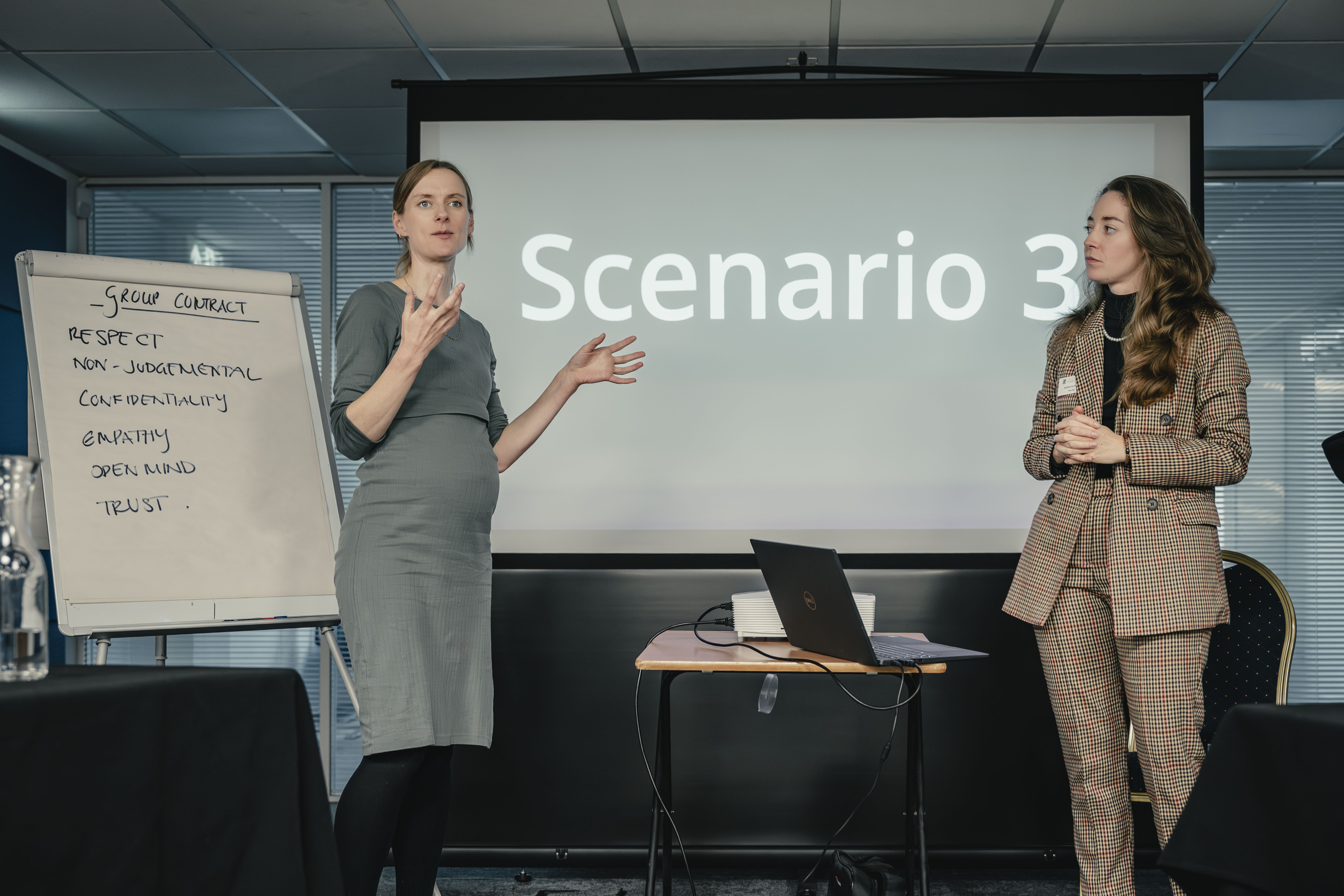 Two women presenting in front of a screen